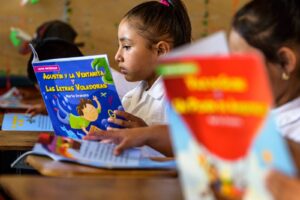 Niña leyendo un libro en el colegio