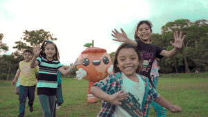 Niñas y niños de El Salvador corriendo en el campo.