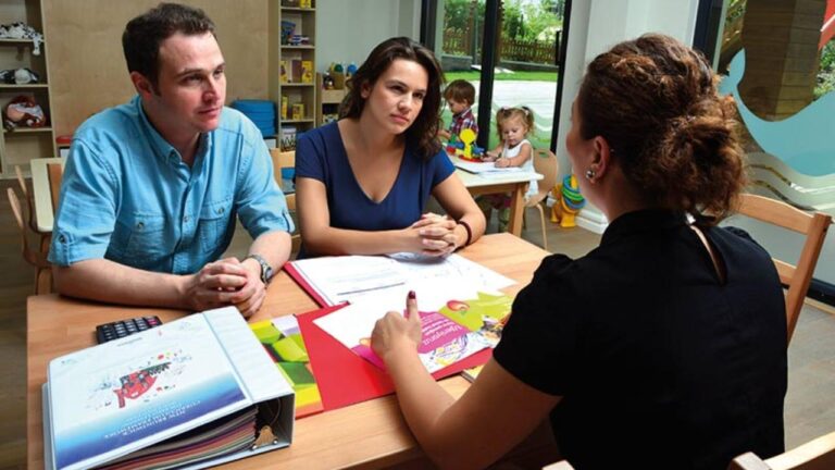 Maestra hablándole a padres de familia sobre la conducta disruptiva de sus hijos