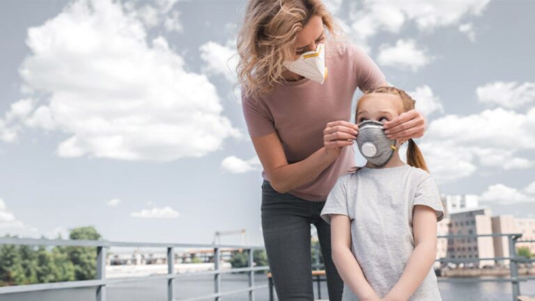 Madre cuidando a su hija de los tipos de contaminación ambiental