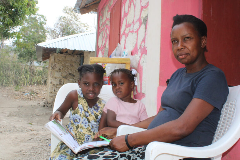 dos niñas con un libro junto a su mamá