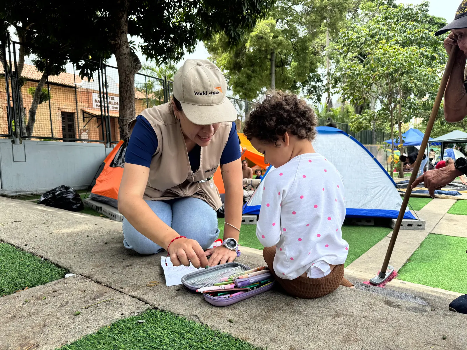 Trabajadora humanitaria de World Vision brinda apoyo psicosocial a una niña en un Espacio Amigable para la Niñez tras el terremoto en Venezuela.